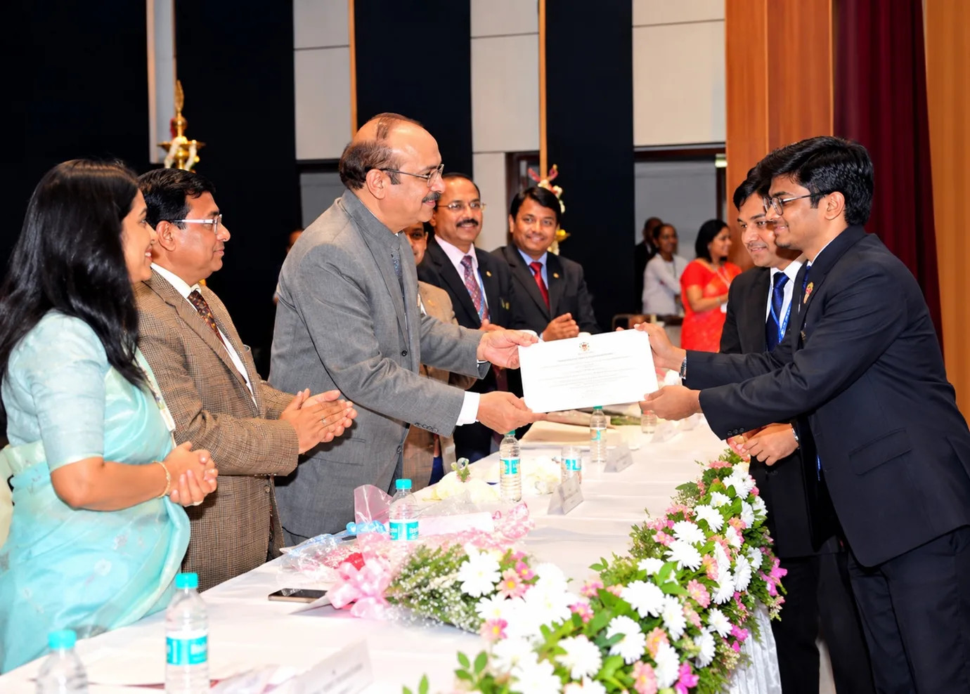 Dr. Satyam Agarwal receiving an award certificate on stage